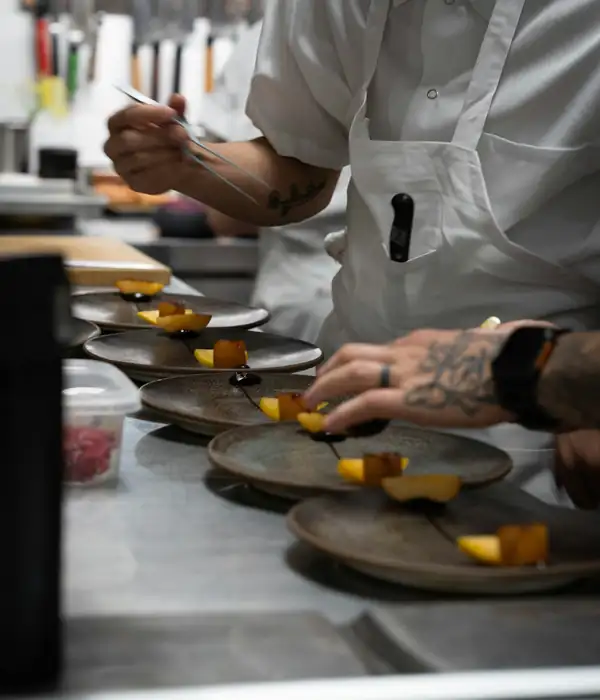 A chef plating dishes in a restaurant kitchen